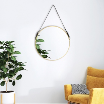 Round mirror with gold frame on the wall